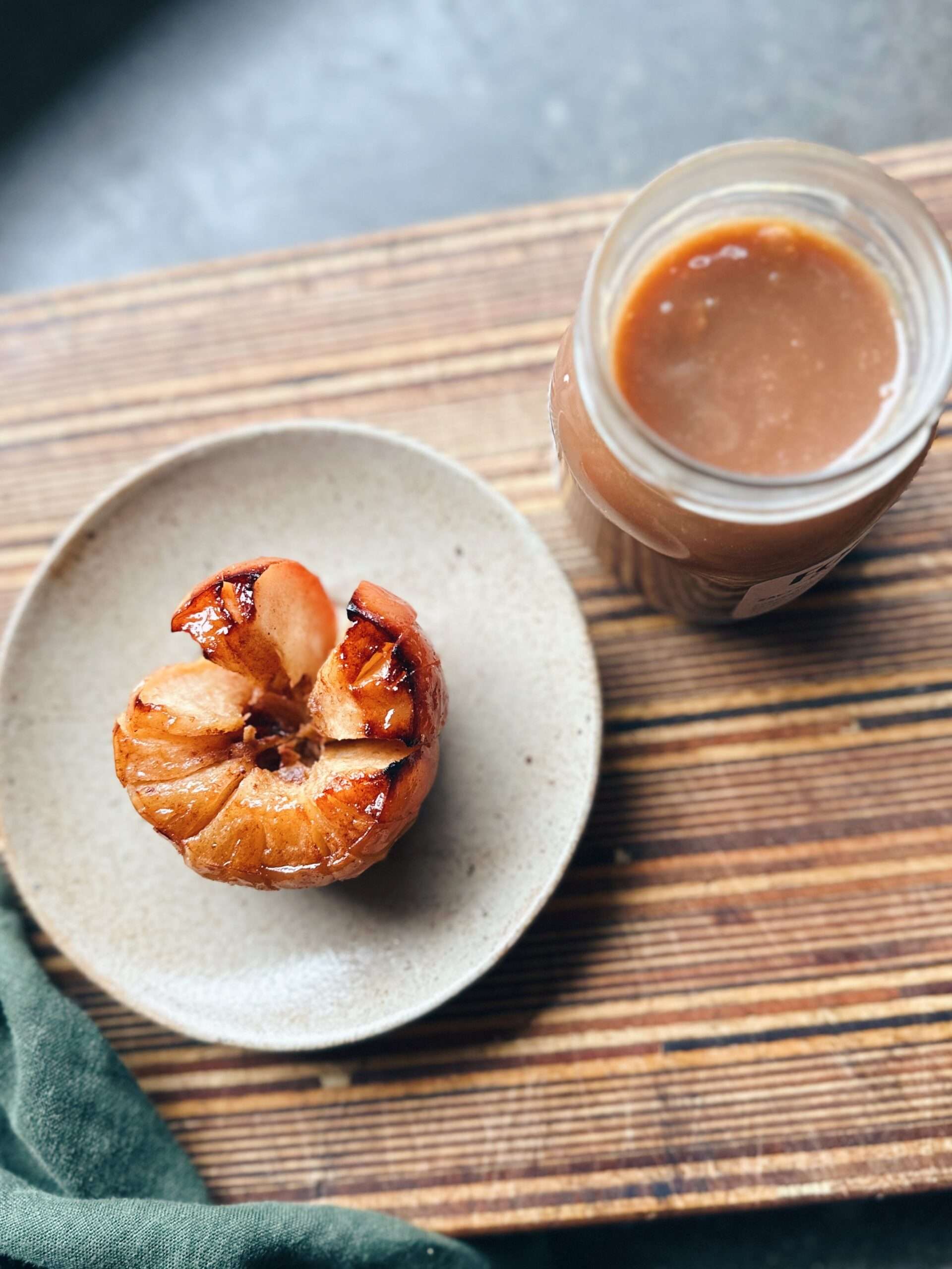 Cooked apple on chopping board with jar of irish cream liqueur caramel